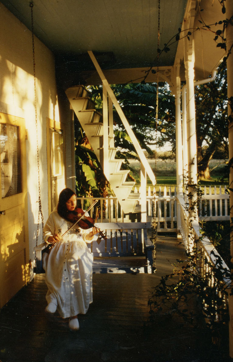 Ann on porch playing fiddle by Lucinda Lambton