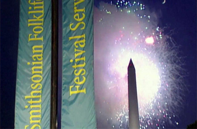 Vertical banners reading Smithsonian Folklife Festival in front of a night sky, the Washington Monument silhouetted by bursting fireworks.